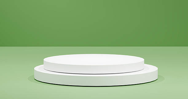 istock White round podium stands on a light green background, bathed in soft, diffused lighting. Modern product display platform for showcasing cosmetics to tech, emphasizing simplicity in presentations. 2218783761