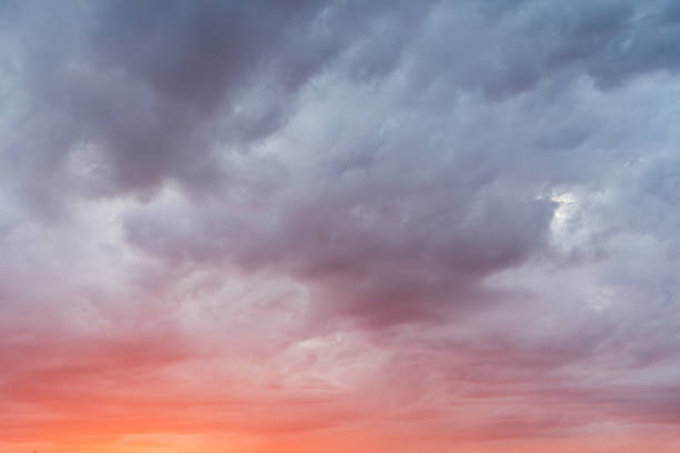 istock Dramatic sunset clouds: dark heavy clouds at the top contrast with the bright orange-red light on the horizon. 2218784778