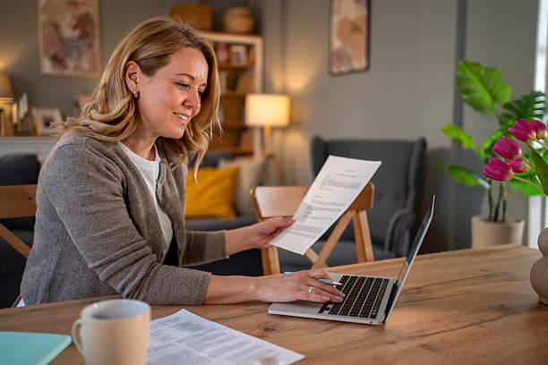 istock Woman working from home on laptop and reading documents 2218784899