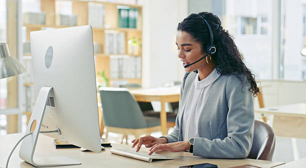istock Professional Woman Working in Office Environment With Headset and Desktop Computer 2218785743
