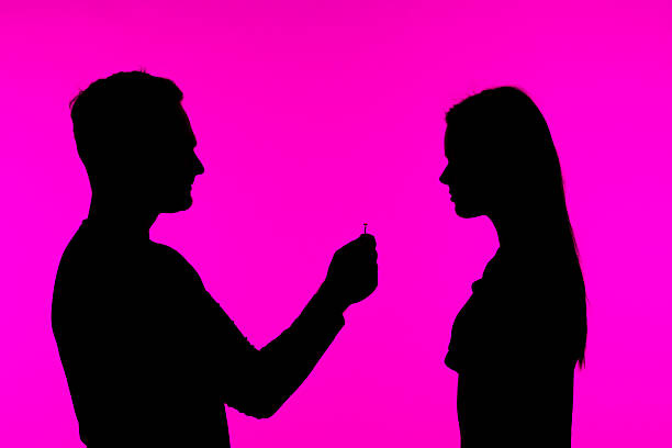 istock Silhouette of a Proposal with Ring Against Pink Background 2218786503