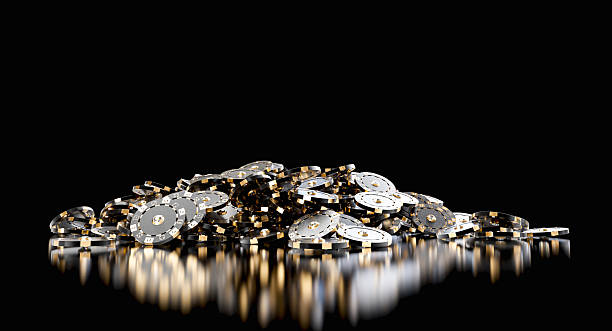 Black and gold poker chips piled up on reflective black background