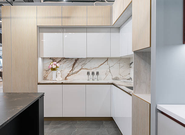 istock large corner built-in kitchen in white and beige shades. Modern kitchen with upper and lower cabinets. white marble countertop and backsplash. Built-in kitchen appliances. The cabinet doors are open 2218788105