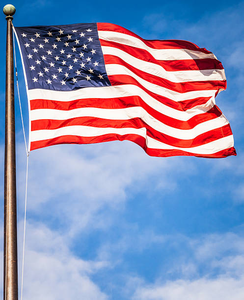 Close up of a large American flag, flying in the wind on a sunny day.