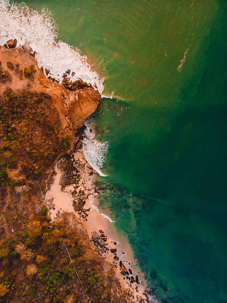 istock Top down drone view of rocky shore with ocean, waves and warm sun light 2218789455
