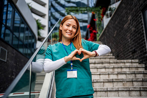 istock Young smiling nurse making heart shape with hands outdoors 2218791014