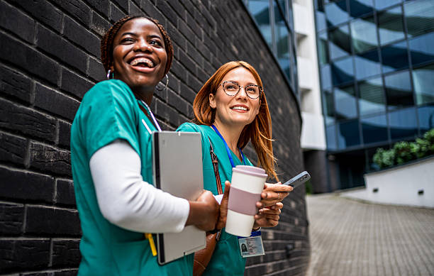 istock Two smiling nurses standing and talking outside hospital 2218791154