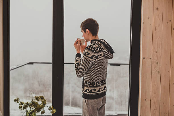 istock Man Drinking Morning Coffee in Log Cabin 2218793232