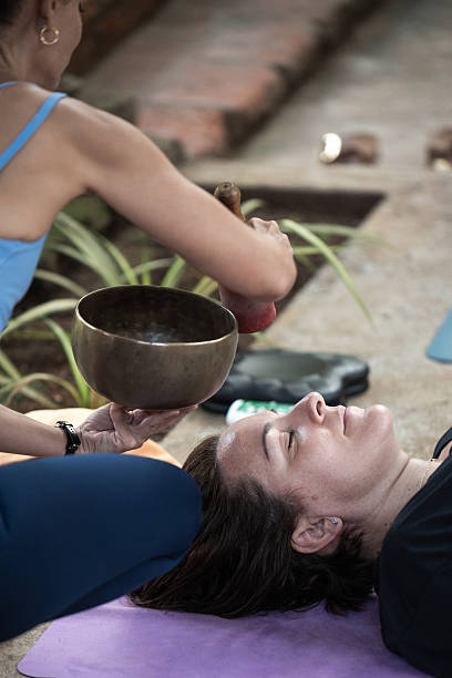 istock Therapist performing sound healing with tibetan singing bowl 2218795406