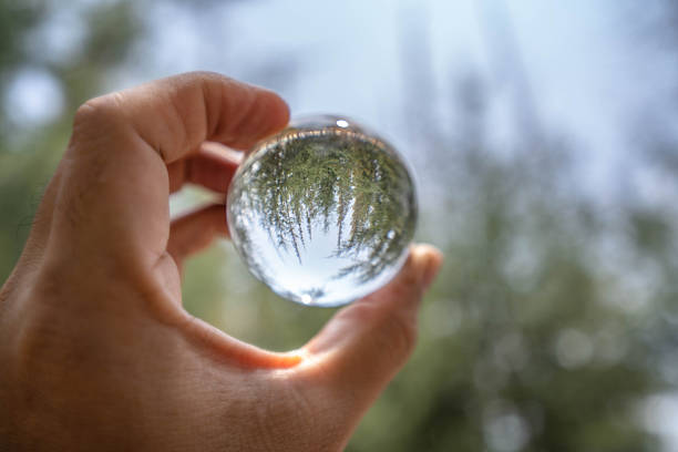 istock Hand Holding Crystal Ball with Reflected Sky and Trees – Artistic Perspective on Nature and Reflection 2218795561
