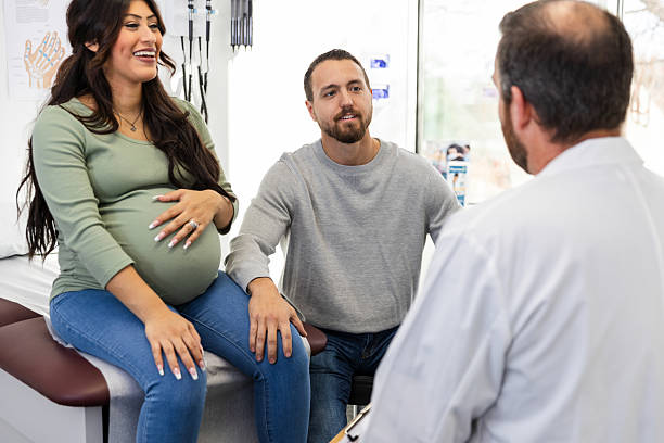 istock Expectant Couple Consulting with Doctor during Prenatal Visit 2218796047