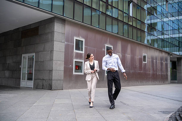 istock Businesspeople walking and talking outside office building 2218797116