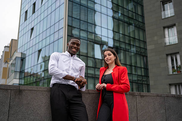 istock Smiling business people leaning on wall in urban setting 2218797224