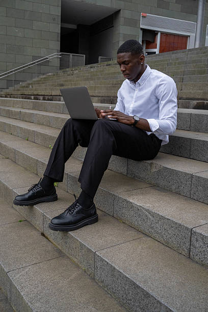 istock Businessman working on laptop outdoors on steps 2218798141
