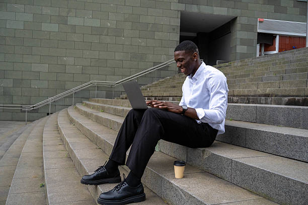 istock Businessman working remotely on laptop on city steps 2218798213