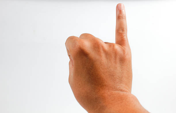 A boy holds his little finger up in a clenched fist.