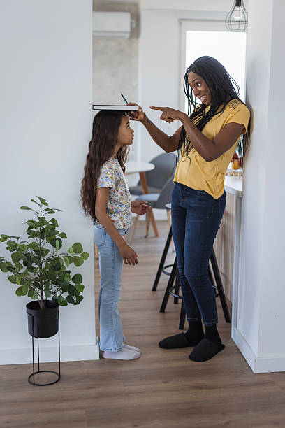 istock Woman measuring her daughter's height 2218799246