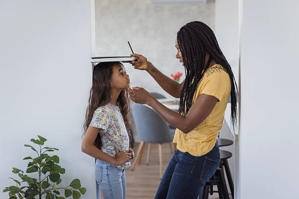 istock Mother measuring her daughter's height 2218799256