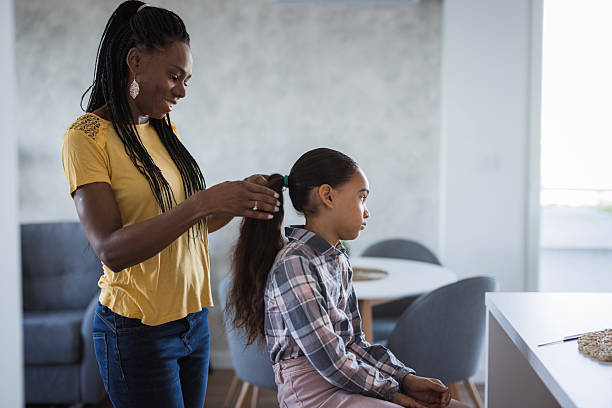 istock Mother brushing her daughters afro hair 2218799435
