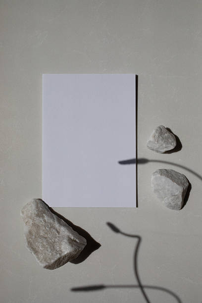 istock Blank card with white decorated rock stones and sunlight shadows on neutral background. Aesthetic composition for minimalistic brand template and presentation. 2218802949