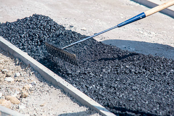 istock Construction workers in high-visibility gear are applyin gfresh hot asphalt to roadway surface 2218803776
