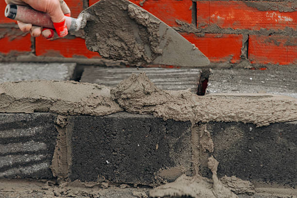 istock Hard-working bricklayer laying concrete blocks on housing site helping eliminate housing crisis by building more affordable houses concept 2218804661