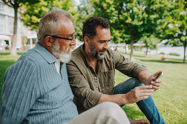 istock Son showing older father something in smartphone, sharing a joyful moment . 2218805251