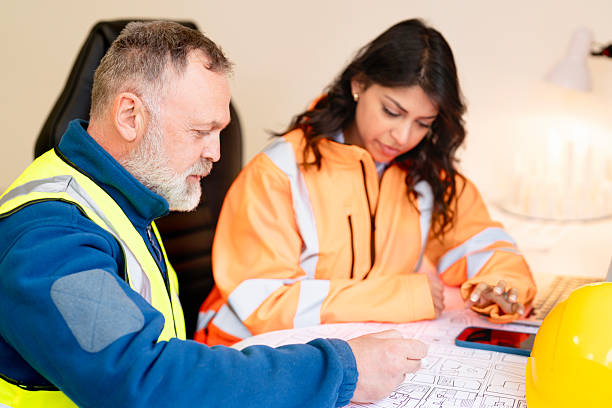 istock Construction project manager and architect collaborating to discuss blueprints drawings and plans at workspace office 2218807458