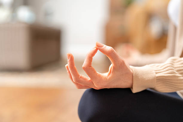 Mindfulness practice taking place indoors as a person engages in meditation while seated on a wooden floor during a peaceful afternoon