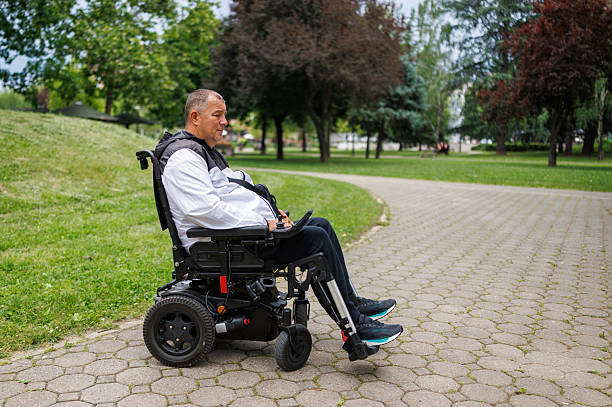 istock Sad Man Taking a Stroll in Wheelchair on Paved Path 2218812886