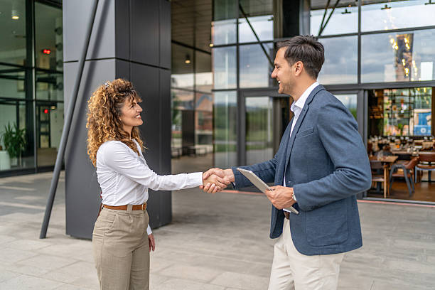 istock Businesspeople shaking hands outside office building 2218813979