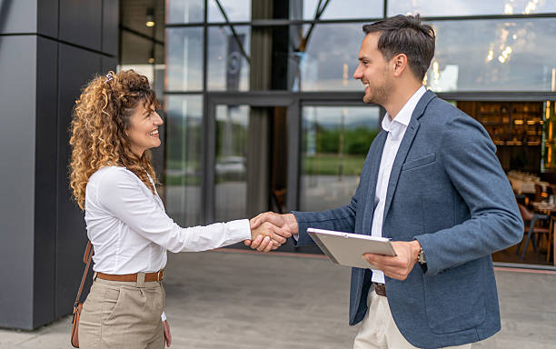 istock Businesspeople shaking hands outside office building 2218814016