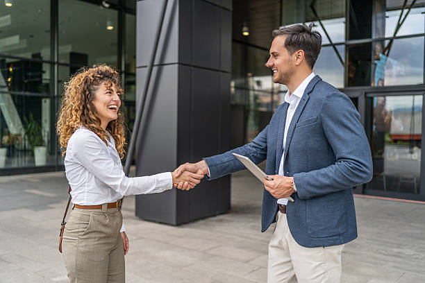 istock Businesspeople shaking hands outside office building 2218814435