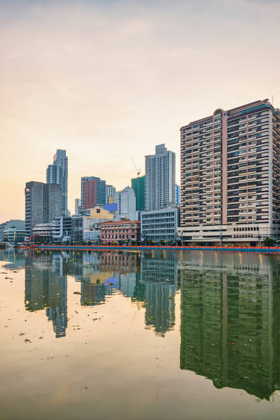 Skyline and Pasig River in downtown Manila, Philippines at sunset.