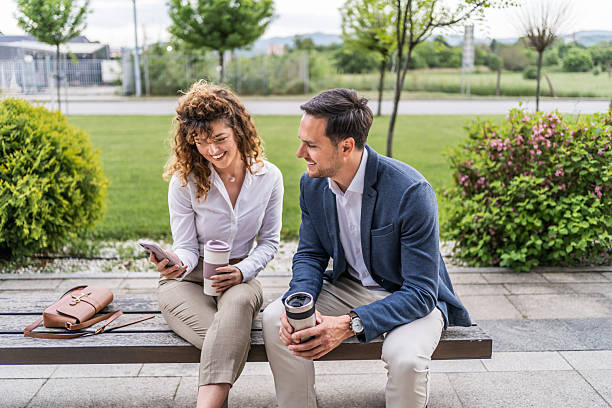 istock Business people relaxing outdoors while using mobile phone and drinking coffee 2218815173