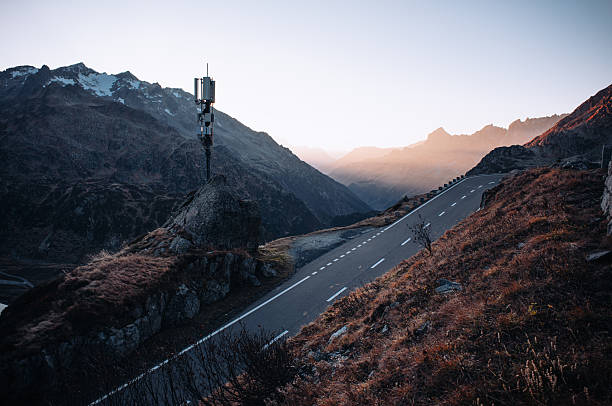 Breathtaking mountain road winding through the Susten Pass in the Swiss Alps, captured on a scenic summer road trip. Dramatic alpine peaks, lush green valleys, and clear blue skies create a stunning natural landscape. Ideal for travel, adventure, freedom, and nature concepts.