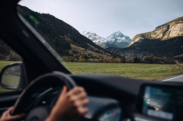 Breathtaking mountain road winding through the Susten Pass in the Swiss Alps, captured on a scenic summer road trip. Dramatic alpine peaks, lush green valleys, and clear blue skies create a stunning natural landscape. Ideal for travel, adventure, freedom, and nature concepts.