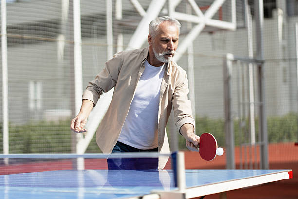istock Senior man playing ping pong outdoors, enjoying active retirement 2218823025