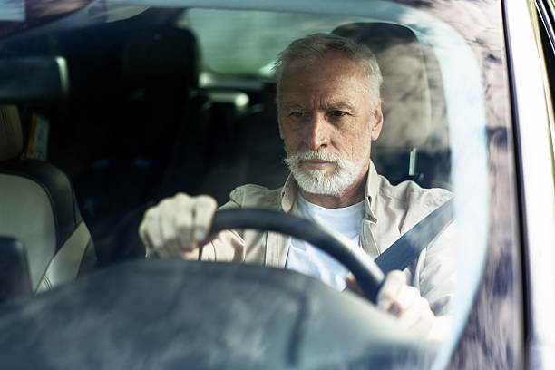 istock Senior man driving a car, looking focused on the road 2218823042