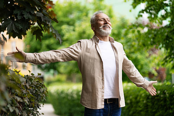 Senior man enjoying fresh air in a green park
