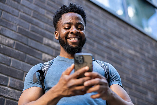 istock Man Smiling at Phone Outdoors in City 2218824998