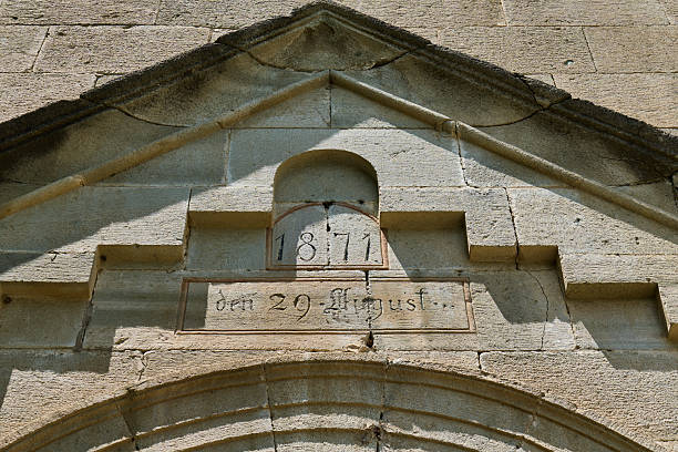 Stone archway features an inscription detailing a date in August 1871