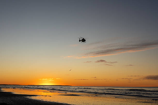 Beautiful golden sunset at the sea with helicopter in the sky