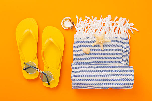 istock Beach towel with summer accessories on color background, top view 2218828293