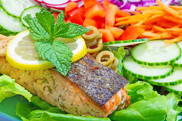 Pan seared salmon crispy skin side up on bed of colorful raw vegetables.