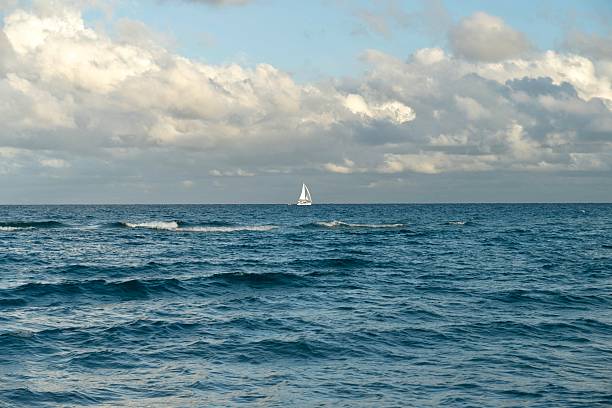 istock Lone Sailboat on a Calm Ocean Horizon 2218829071