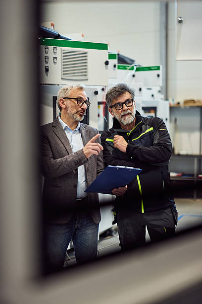 istock Two Professionals Discussing Project Plans in a Modern Industrial Environment 2218829702