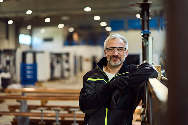 istock Confident Factory Worker in Safety Gear Smiling Inside an Industrial Setting 2218829712