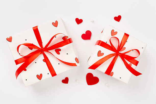 istock Festive gift boxes with red hearts on color background, top view 2218832655