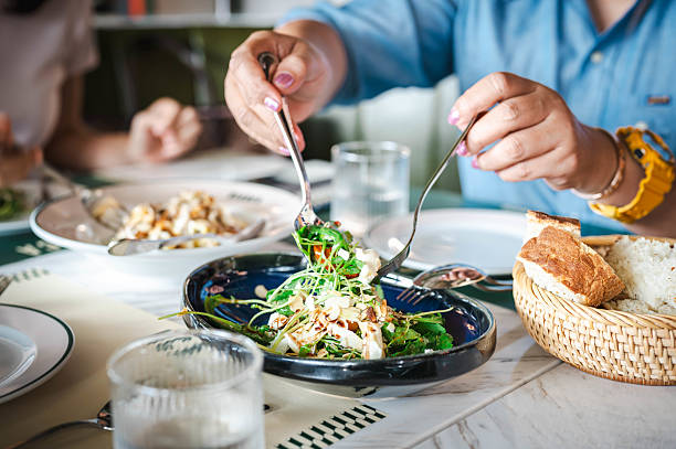 istock A woman's hand is using a spoon and fork to scoop rocket and ricotta cheese salad. 2218836524